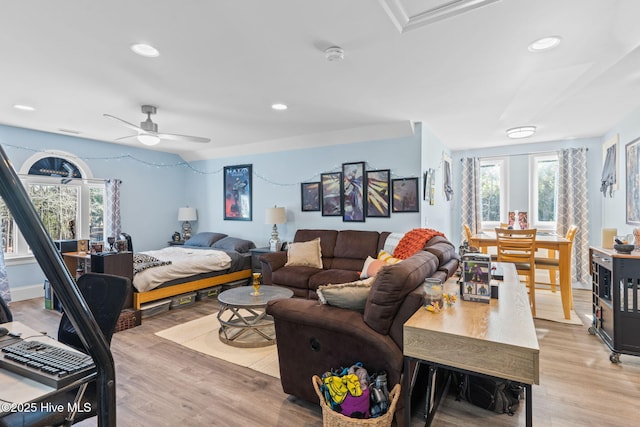 bedroom featuring ceiling fan, multiple windows, and light wood-type flooring