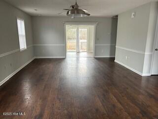 empty room featuring dark wood-type flooring and ceiling fan