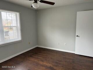 unfurnished room featuring dark hardwood / wood-style flooring and ceiling fan