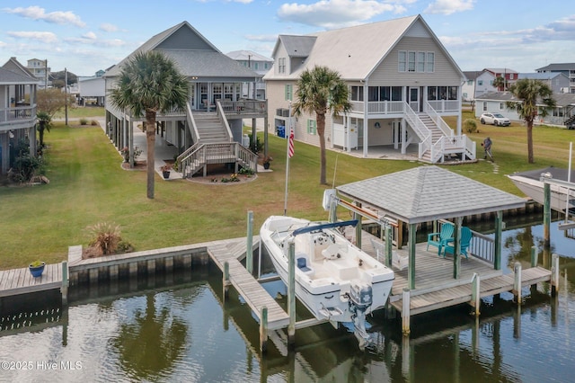 dock area featuring a deck with water view and a lawn