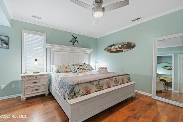 bedroom with dark hardwood / wood-style flooring, ornamental molding, and ceiling fan