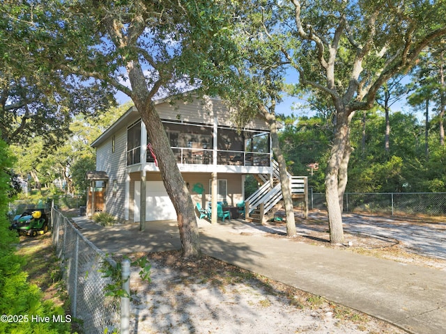 raised beach house featuring a garage and a sunroom