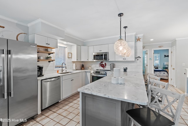 kitchen with sink, appliances with stainless steel finishes, white cabinetry, hanging light fixtures, and ornamental molding