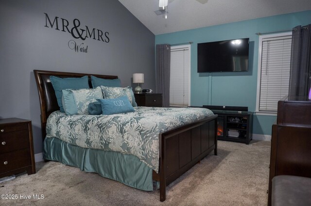 bedroom featuring light colored carpet, ceiling fan, vaulted ceiling, and multiple windows