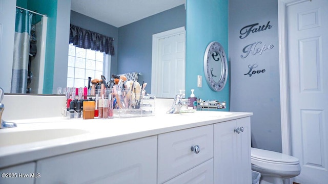 full bath featuring toilet, double vanity, a sink, and a shower with shower curtain