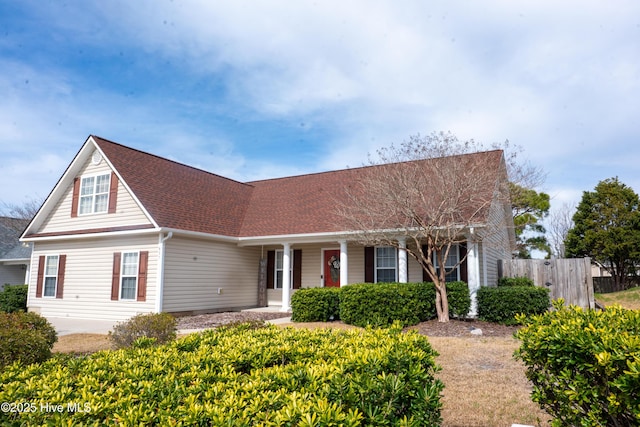 view of front of house with a shingled roof and fence