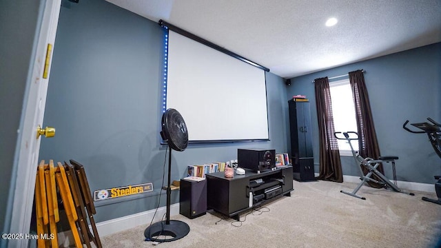 cinema with baseboards, a textured ceiling, and light colored carpet