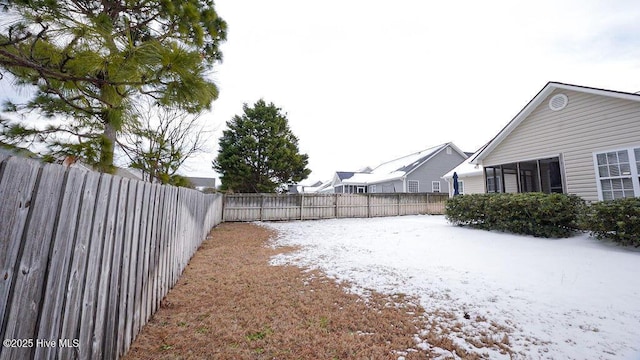 snowy yard with a fenced backyard