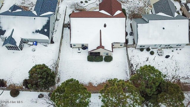 view of snow covered back of property