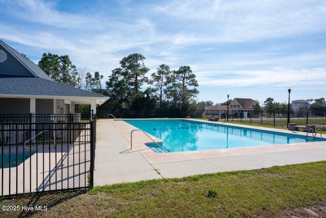 community pool with a patio and fence