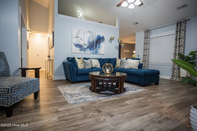 living room with ceiling fan, vaulted ceiling, and hardwood / wood-style floors