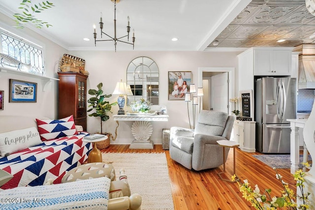 interior space with an inviting chandelier, ornamental molding, and light hardwood / wood-style floors