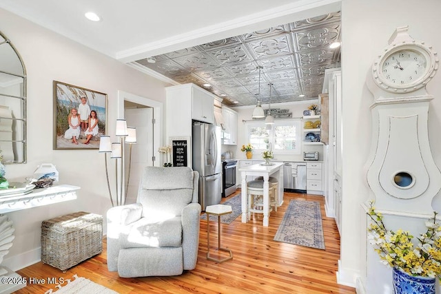 kitchen with white cabinetry, stainless steel appliances, and light hardwood / wood-style floors