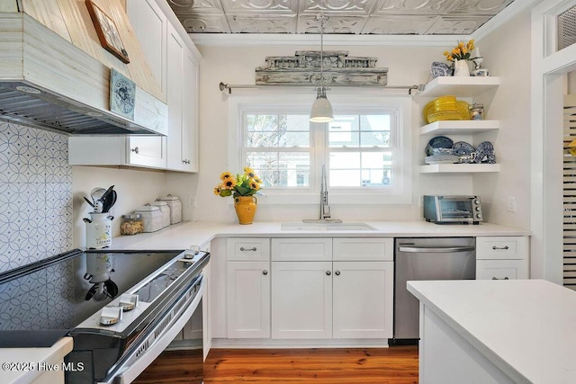 kitchen featuring pendant lighting, sink, white cabinetry, stainless steel appliances, and custom exhaust hood