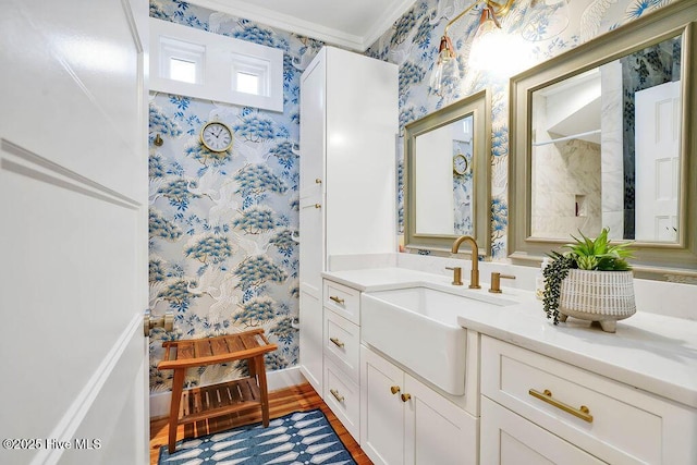 bathroom with ornamental molding, wood-type flooring, and vanity