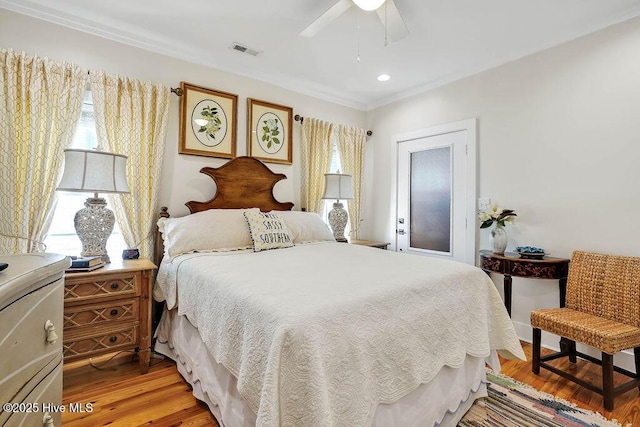 bedroom with ceiling fan, light hardwood / wood-style floors, and multiple windows