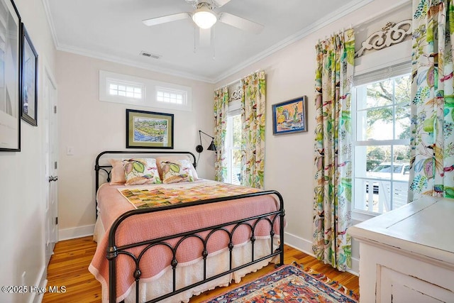 bedroom with crown molding, light hardwood / wood-style flooring, and ceiling fan