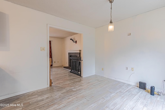 unfurnished living room featuring a fireplace and light hardwood / wood-style flooring