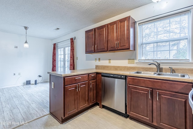 kitchen featuring a textured ceiling, dishwasher, decorative light fixtures, sink, and kitchen peninsula