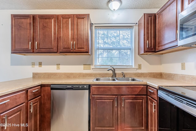 kitchen featuring a textured ceiling, stainless steel appliances, and sink