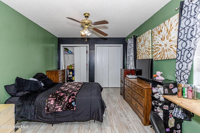 bedroom with a textured ceiling, ceiling fan, and light wood-type flooring