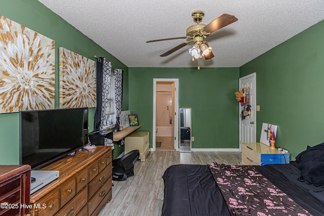 bedroom with ceiling fan, light hardwood / wood-style floors, a textured ceiling, and ensuite bathroom