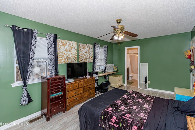 bedroom with ensuite bathroom, ceiling fan, a textured ceiling, and light hardwood / wood-style flooring