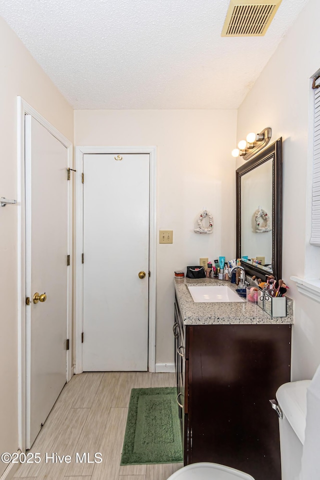 bathroom featuring a textured ceiling and vanity