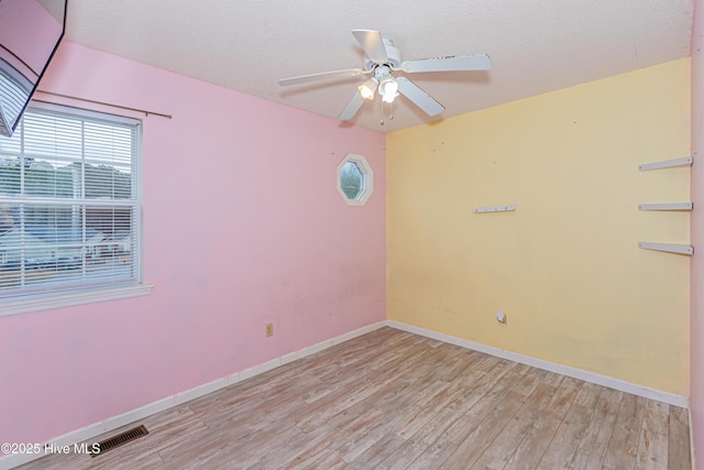 spare room with ceiling fan and light wood-type flooring