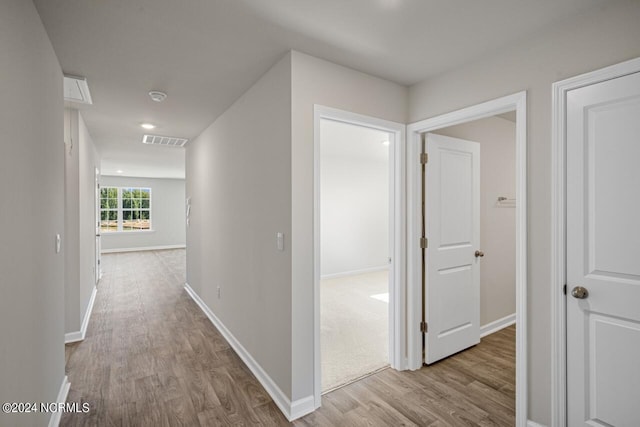 hallway with light hardwood / wood-style floors