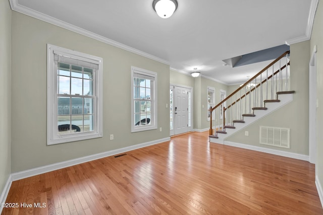 entryway with hardwood / wood-style flooring and crown molding