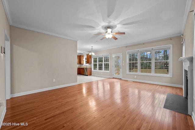 unfurnished living room featuring ceiling fan with notable chandelier, ornamental molding, and light hardwood / wood-style floors