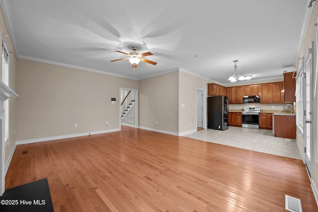 unfurnished living room featuring crown molding, ceiling fan with notable chandelier, sink, and light hardwood / wood-style flooring