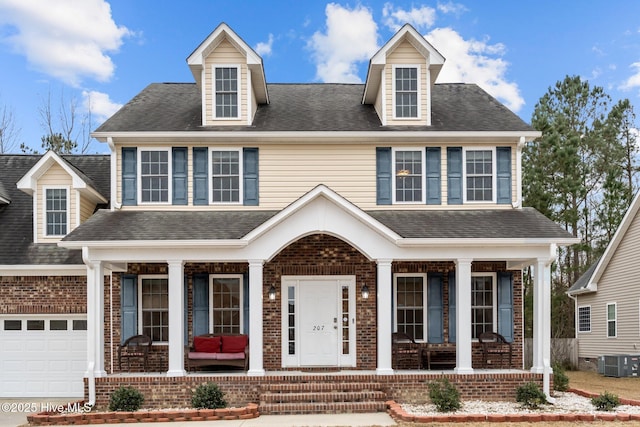 view of front of home with covered porch, central AC unit, and a garage