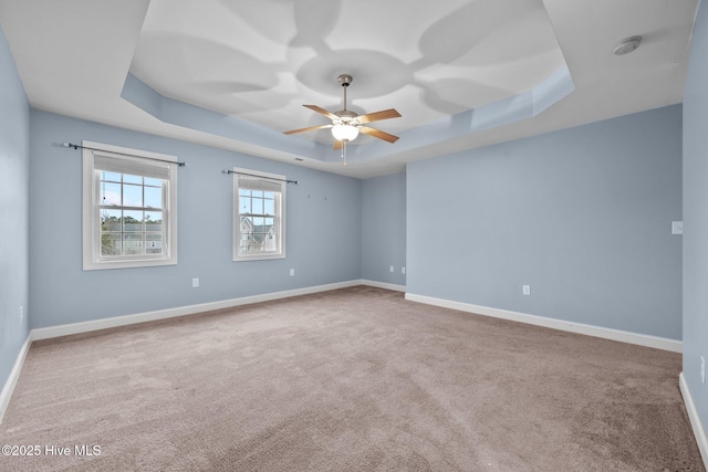 unfurnished room featuring ceiling fan, carpet, and a tray ceiling