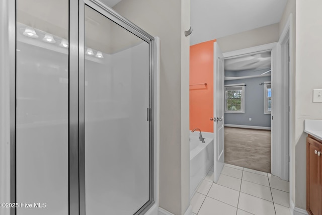 bathroom featuring independent shower and bath, vanity, and tile patterned flooring