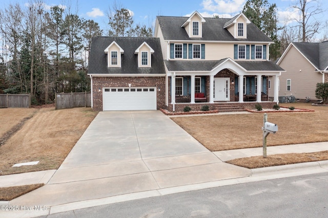 view of front of house with covered porch, a garage, and a front lawn