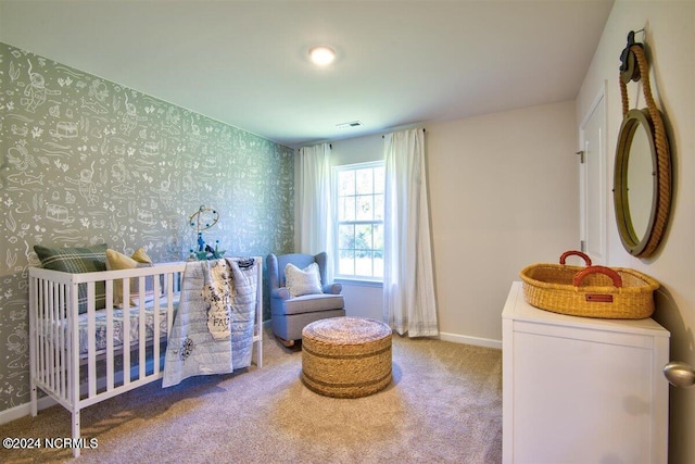 carpeted bedroom featuring a nursery area