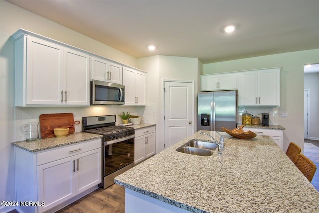 kitchen with sink, white cabinets, stainless steel appliances, and tasteful backsplash