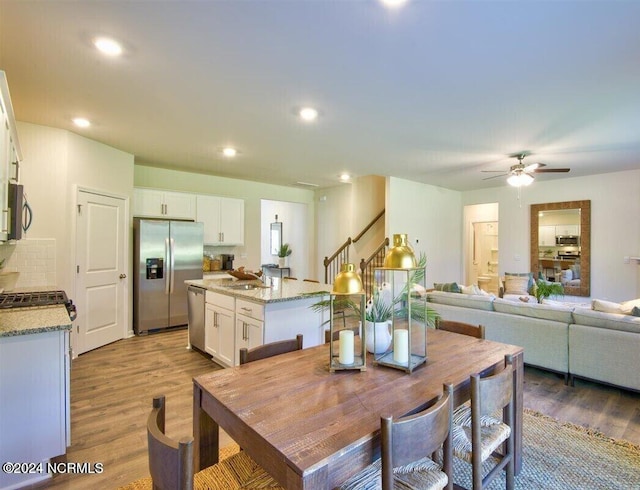 dining area featuring ceiling fan, hardwood / wood-style flooring, and sink