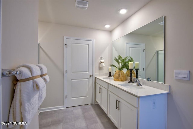 bathroom featuring a shower with shower door and vanity