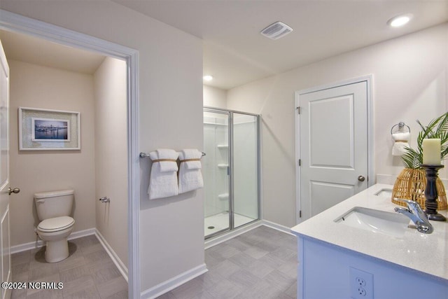 bathroom with a shower with shower door, toilet, and vanity