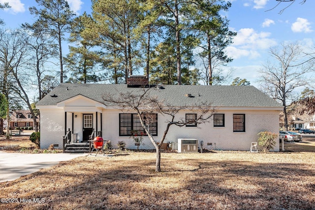 view of front facade with central AC and a front lawn