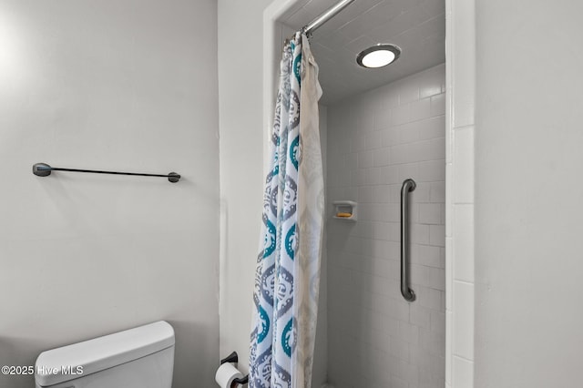 bathroom with toilet and a shower with shower curtain