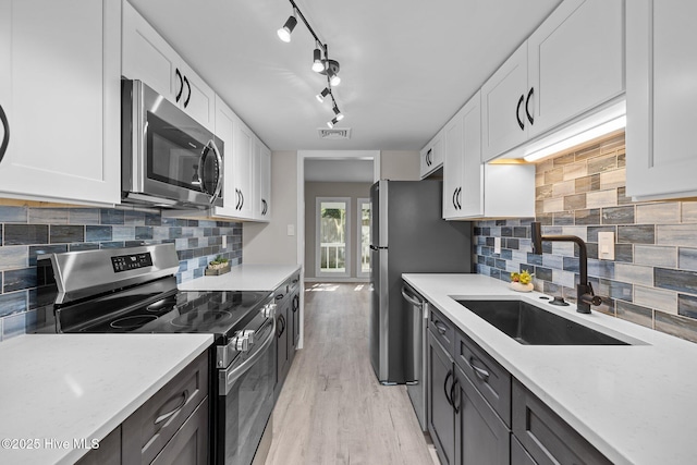 kitchen featuring sink, white cabinetry, light stone countertops, and appliances with stainless steel finishes