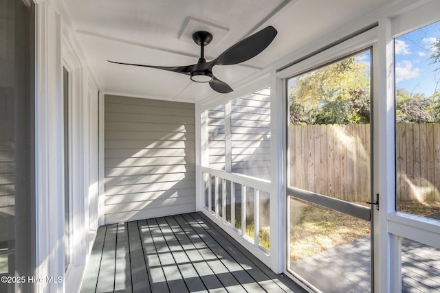 unfurnished sunroom featuring ceiling fan