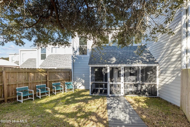 back of property with a sunroom and a yard