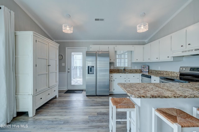 kitchen featuring appliances with stainless steel finishes, pendant lighting, and white cabinets