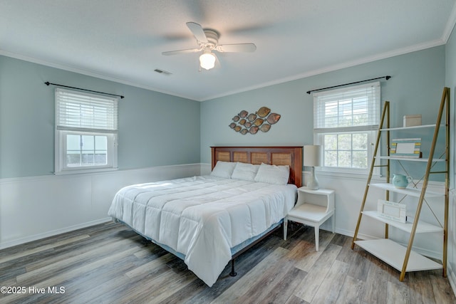 bedroom with wood-type flooring, ceiling fan, and crown molding