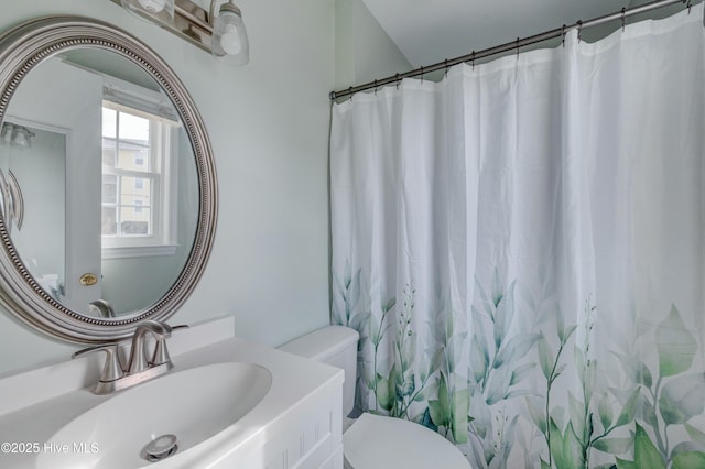 bathroom with a shower with shower curtain, toilet, and sink